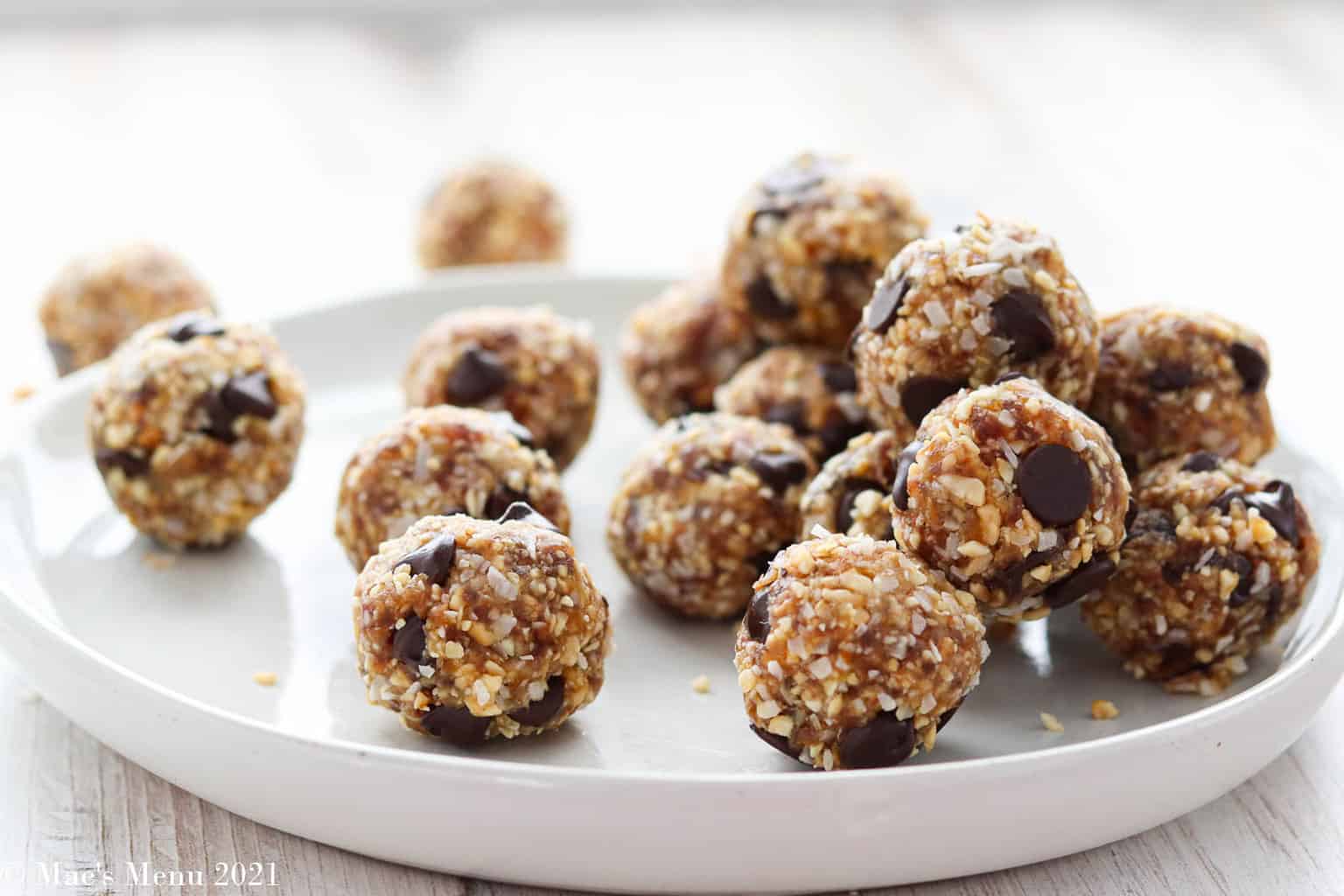A side shot of a plate of grain free date balls on a white plate