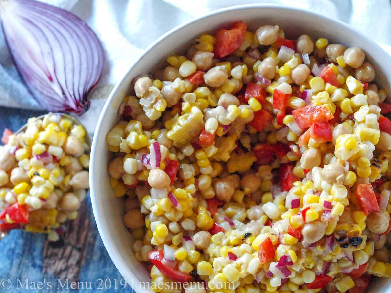 Large white bowl of Chickpea & Grilled Corn Salad with Roasted Garlic Salad Dressing.