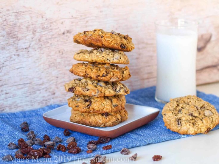 Stack of oatmeal raisin chocolate chip cookies and a glass of milk.