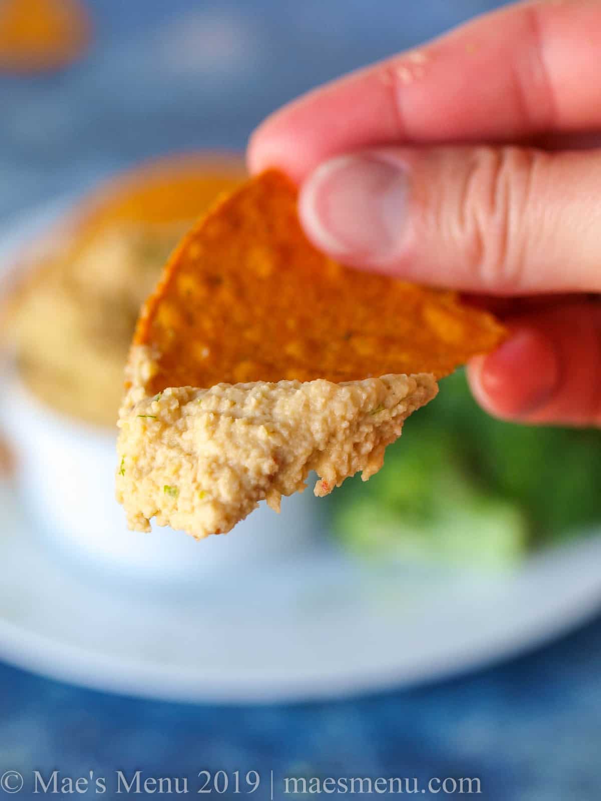Sweet potato chip dipped in curry hummus.