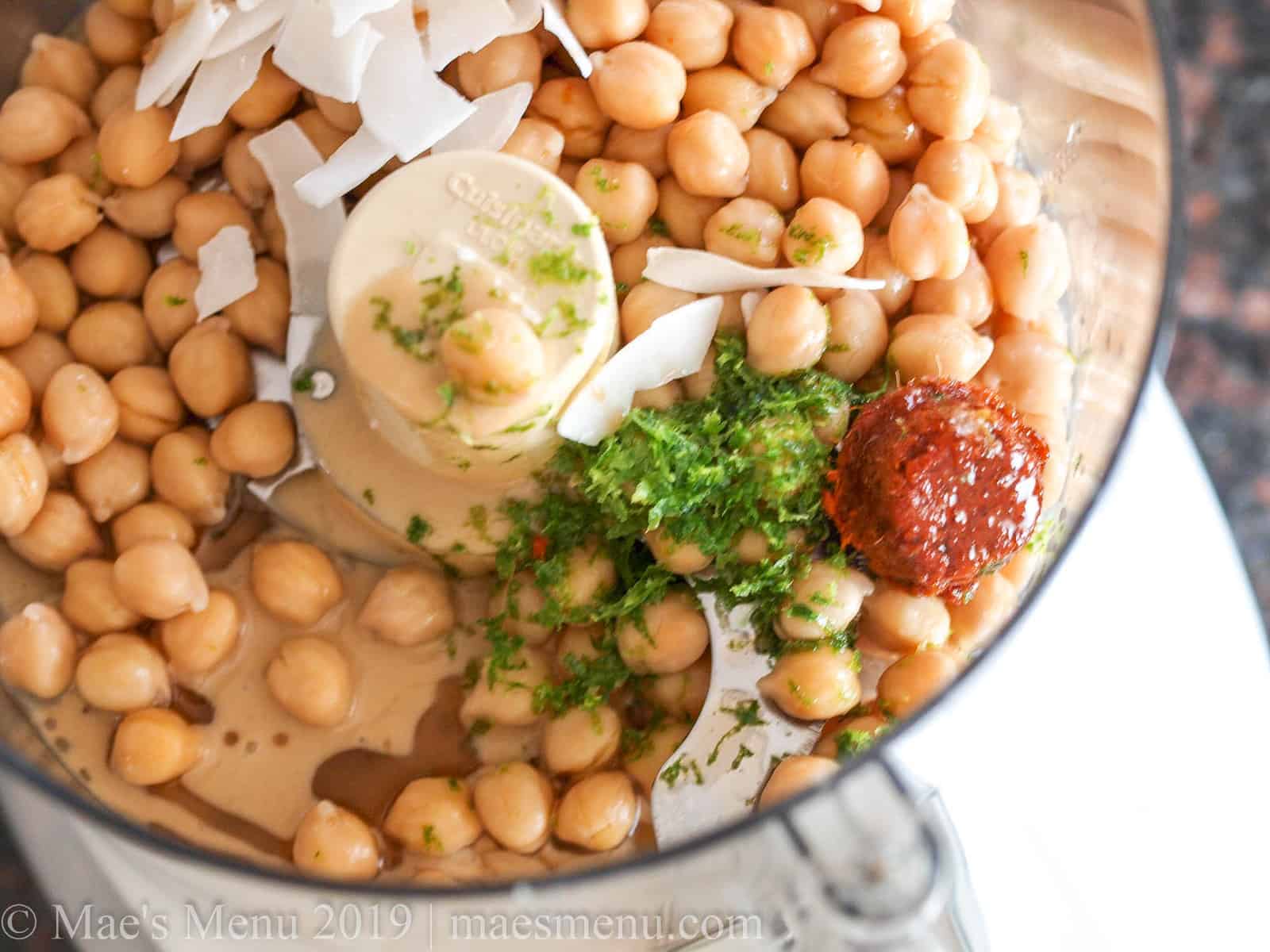 A food processor bowl of curry hummus ingredients.