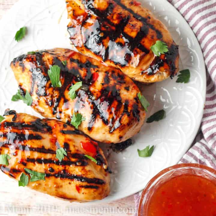 White plate of sweet chili lime chicken breasts.