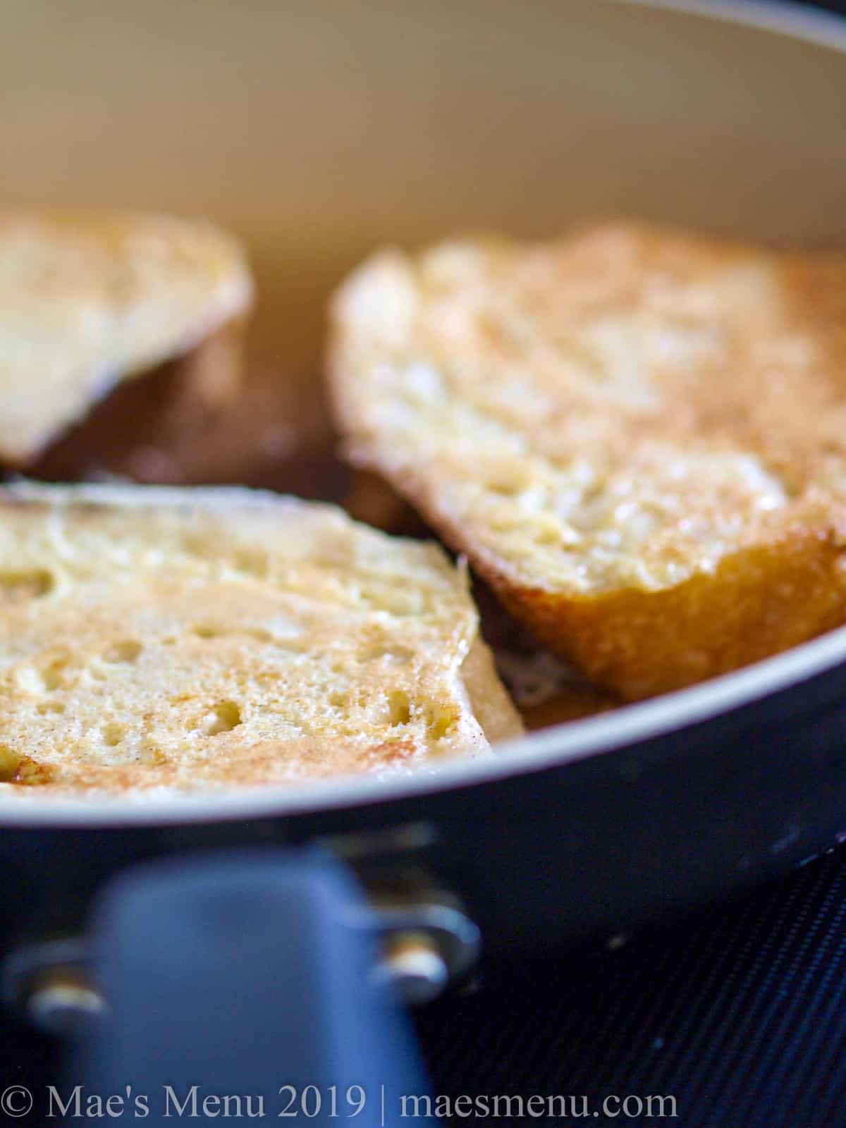 Large slices of healthy french toast cooking in a pan