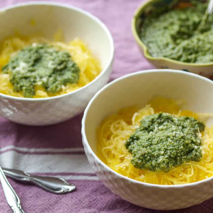 Two bowls of Basil Pesto Spaghetti Squash Pasta and a bowl of pesto.
