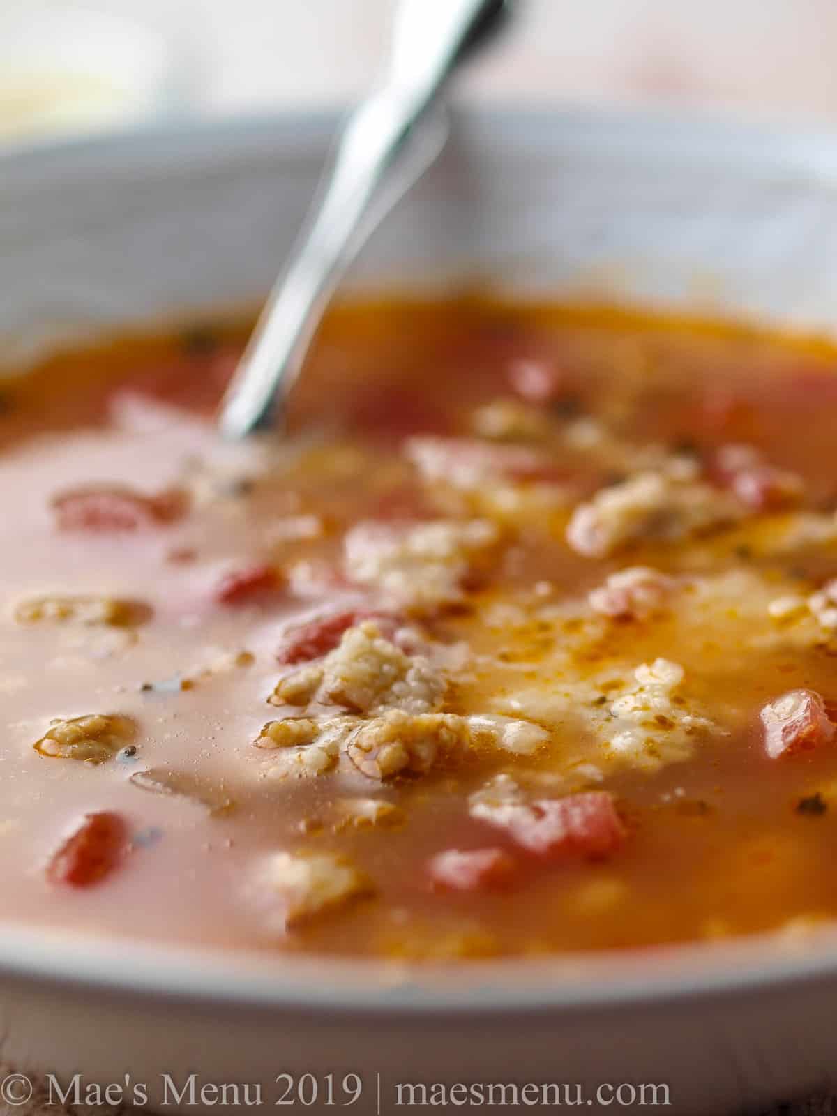 A up-close shot of a large bowl of italian soup with sausage 