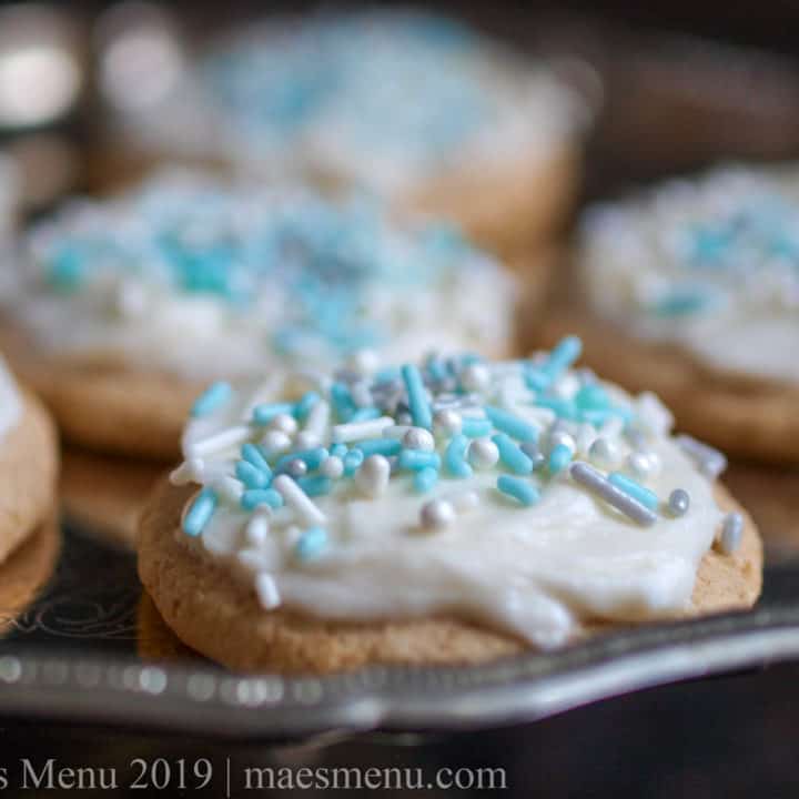 High altitude sugar cookies with vanilla cream cheese frosting. on a silver platter