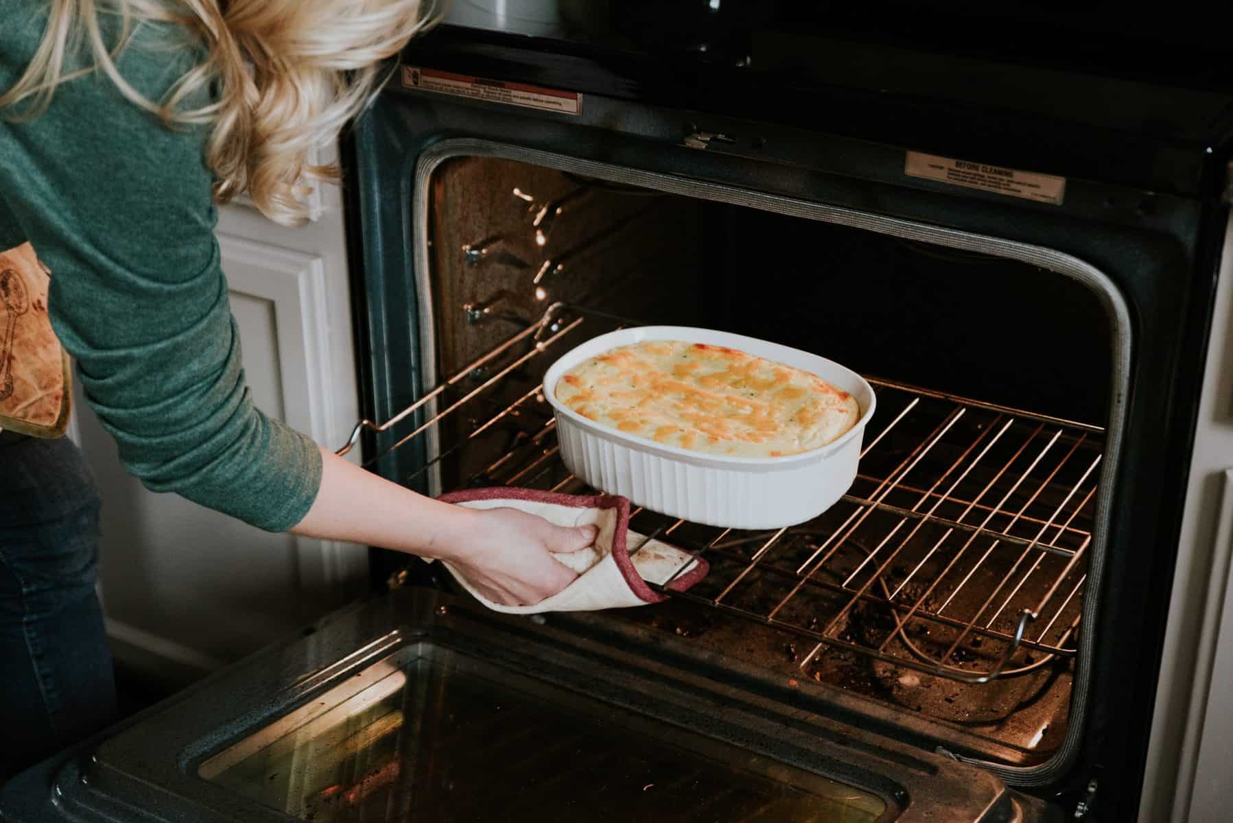 Pulling the mashed potato casserole out of the oven.