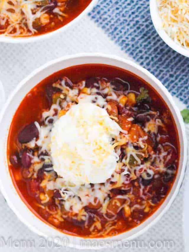Two bowls of instant pot turkey chili next to a large pot of chili.