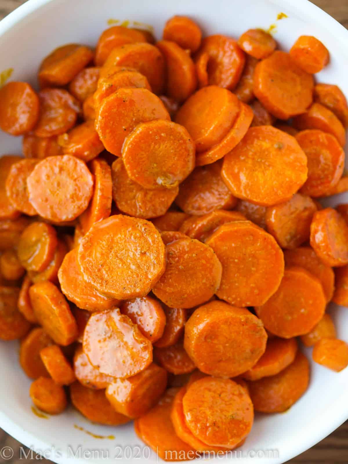An upclose bowl of honey glazed turmeric carrots. 