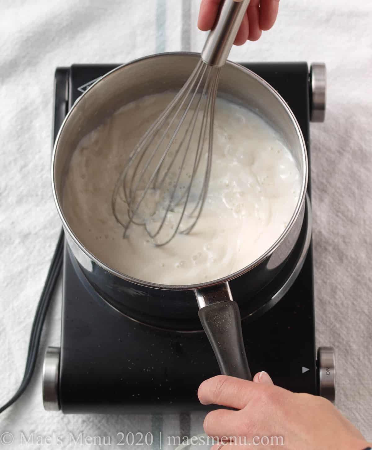 whisking the milk in with the roux 