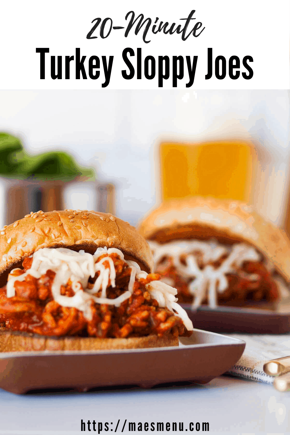 My pinterest pin for turkey sloppy joes. Two plates of sloppy joes in the foreground with glasses of beer and salad in the background.
