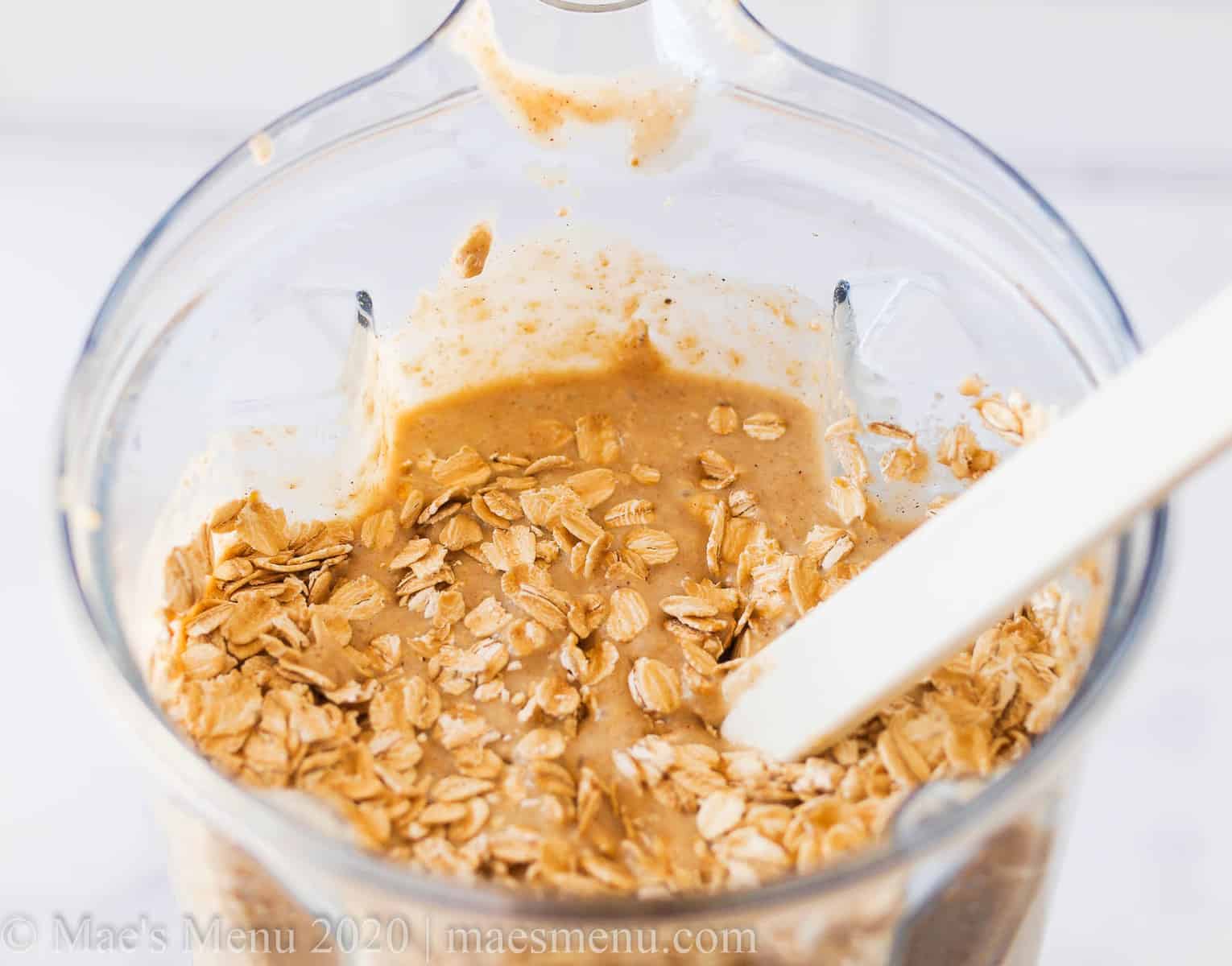 A blender full of banana oatmeal batter with oats mixed in
