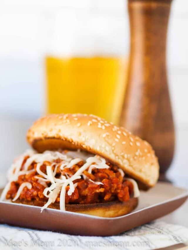Healthy sloppy joes on a white plate iwth a pepper mill and glass of beer in the background.