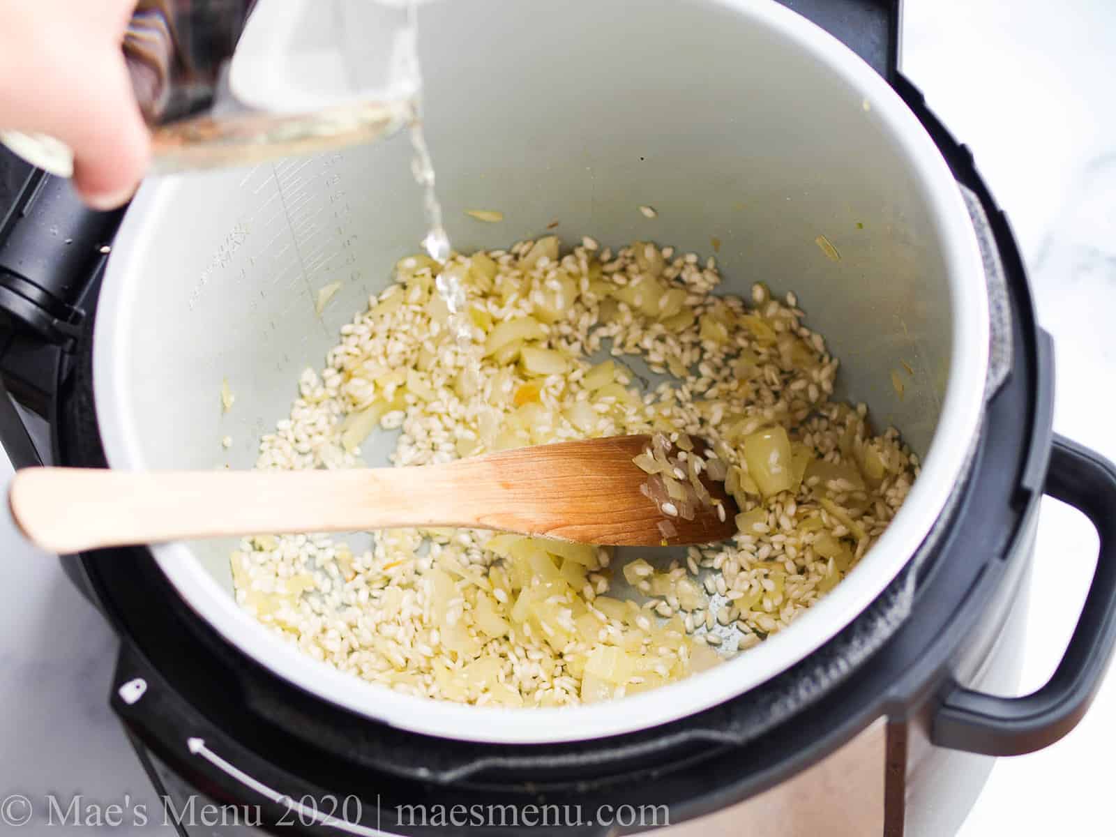 Pouring white wine into the instant pot with the rice