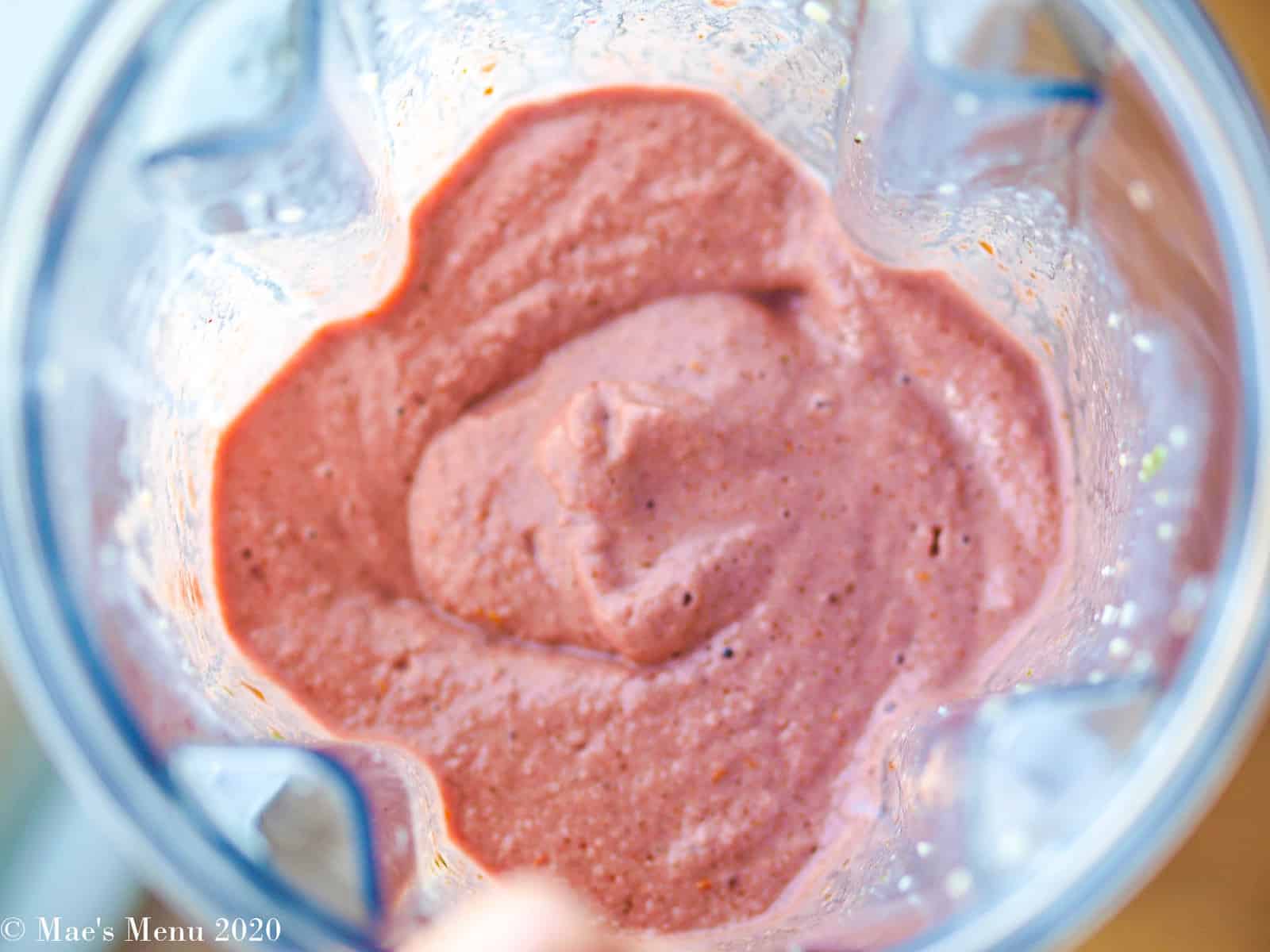 An overhead shot of a pitcher of creamy raspberry smoothie