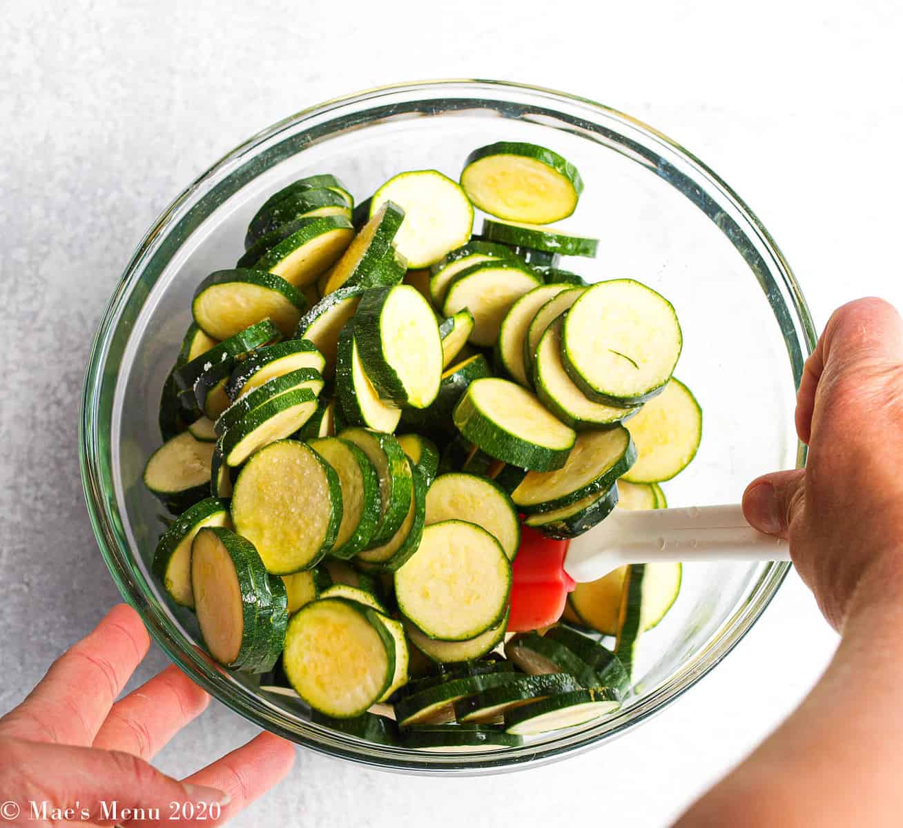 Stirring a bowl of zucchini coins in a mixing bowl