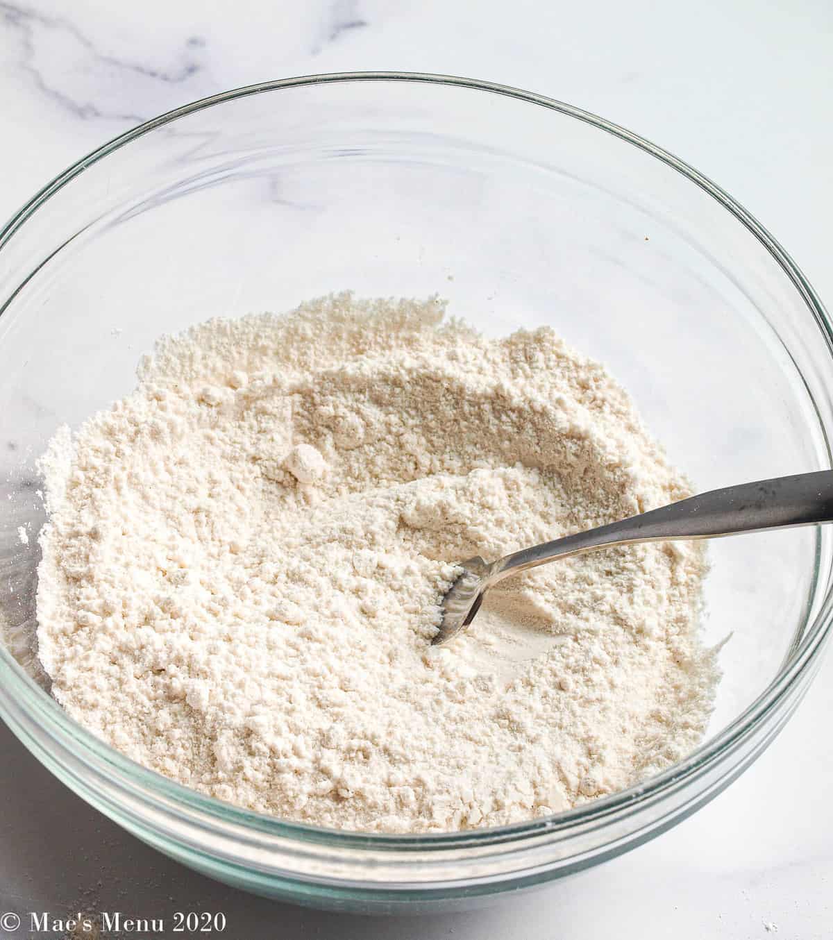 Whisked flour and a fork in a clear glass bowl