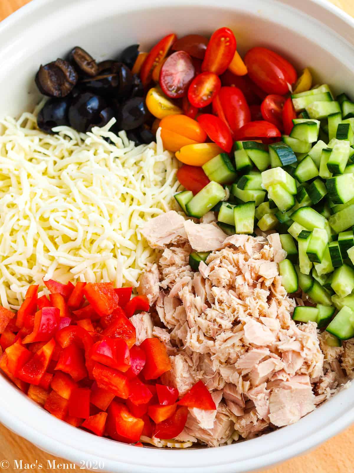An overhead shot of a bowl of tuna pasta salad before stirring.