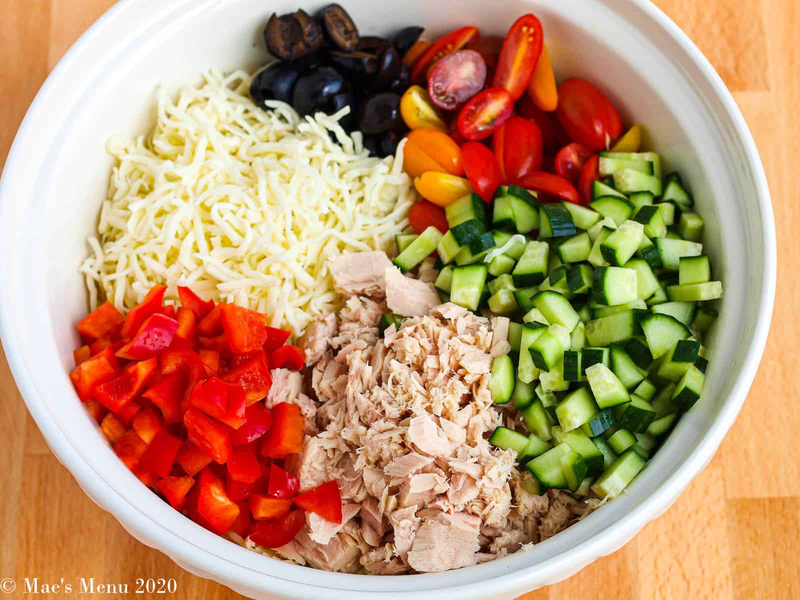 An overhead shot of a bowl full of ingredients before being mixed for the salad. 