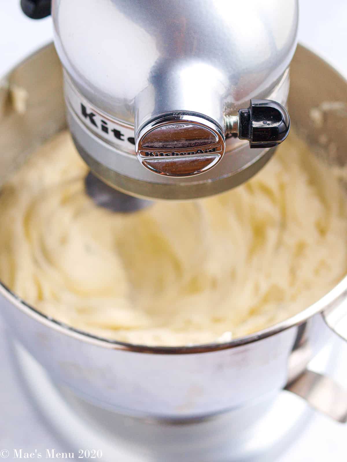 A 90 degree angle shot of a stand mixing whisking up the potato souffle 