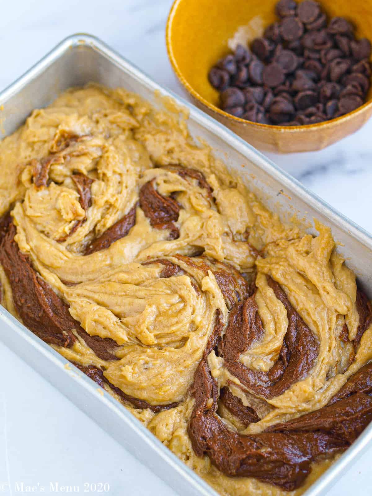 Swirling the peanut butter and chocolate peanut butter banana batter together in a loaf pan
