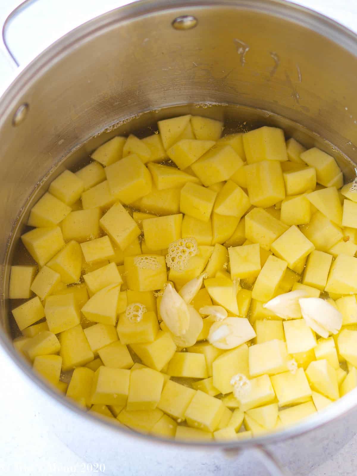 A large pot of potatoes covered with cold water