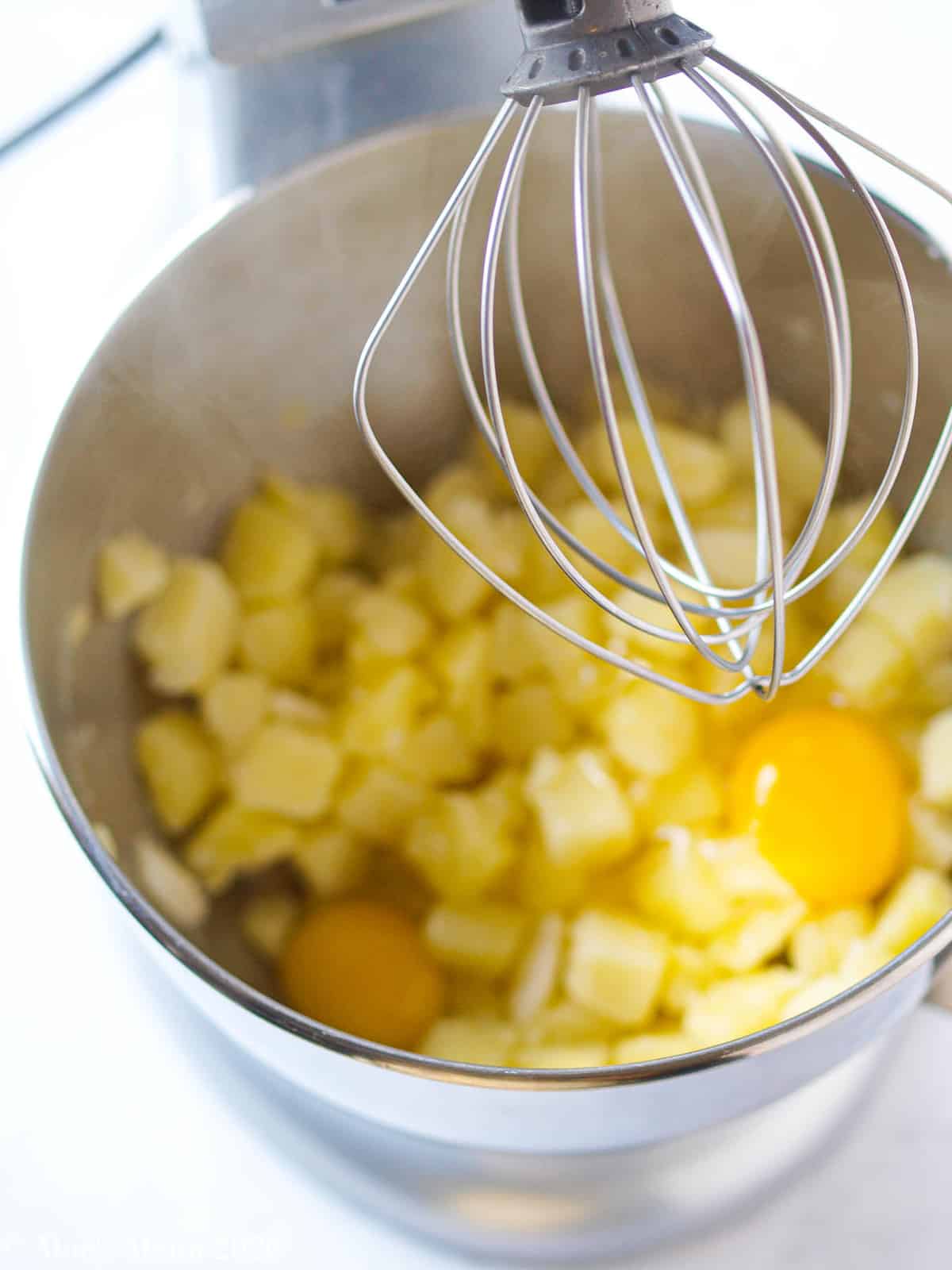 Potatoes, eggs, and salt in a large mixing bowl