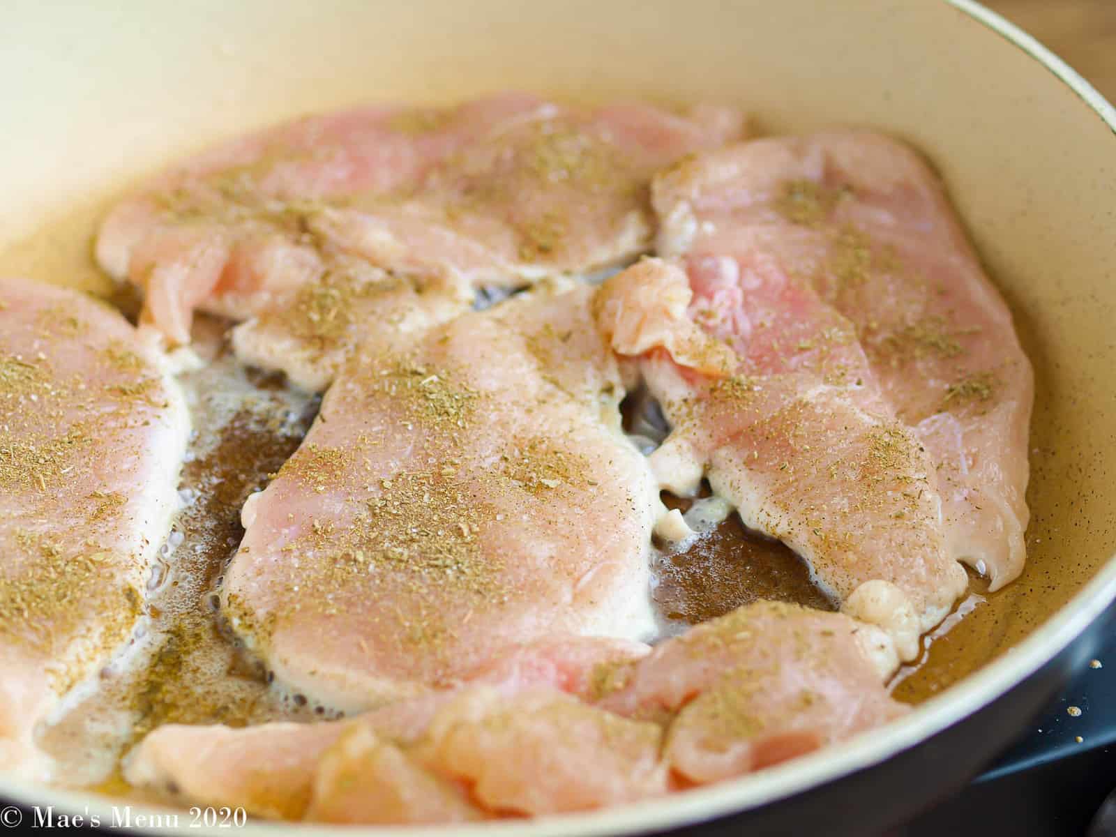 Seasoned chicken in a saute pan
