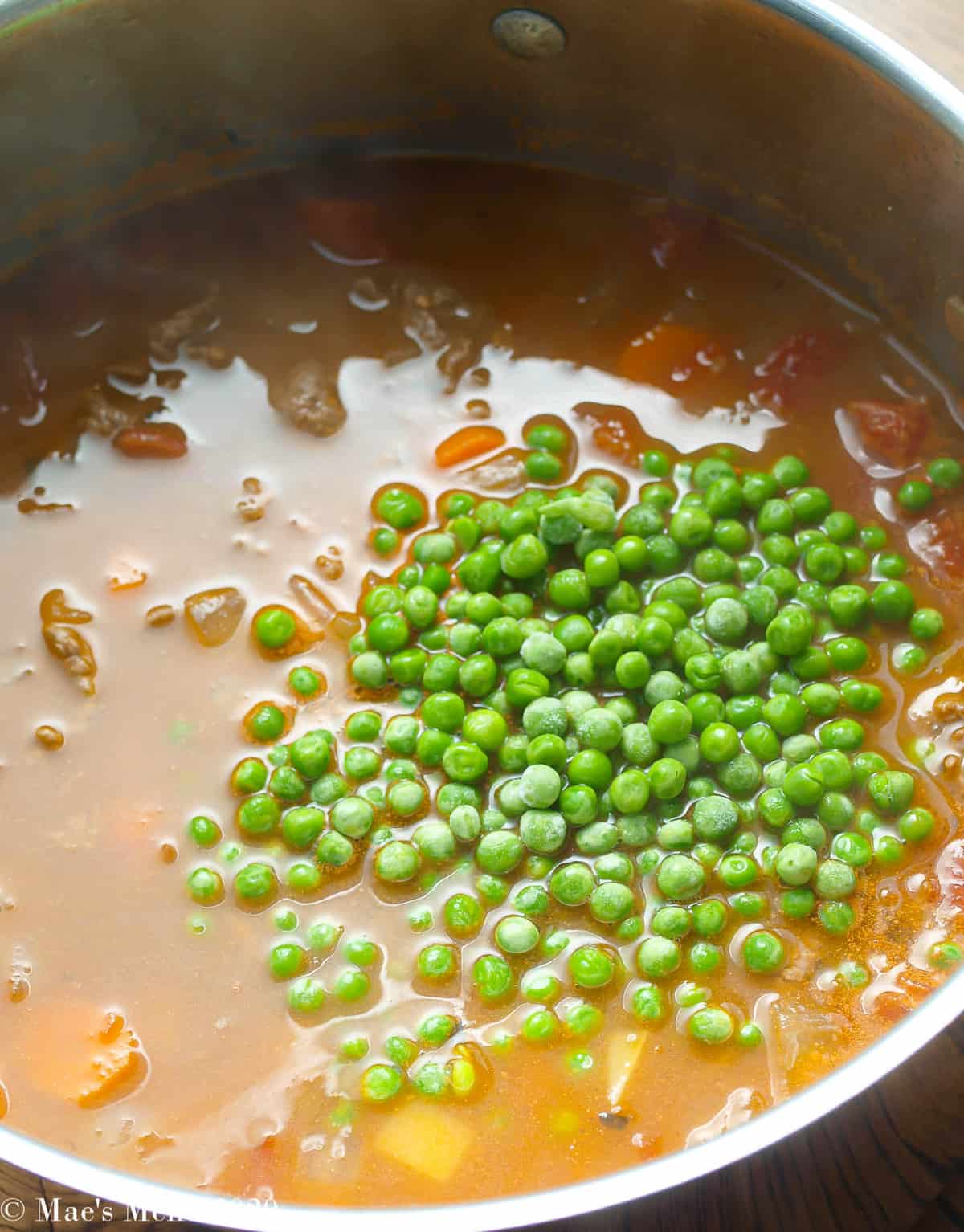 Adding peas to the pot of soup