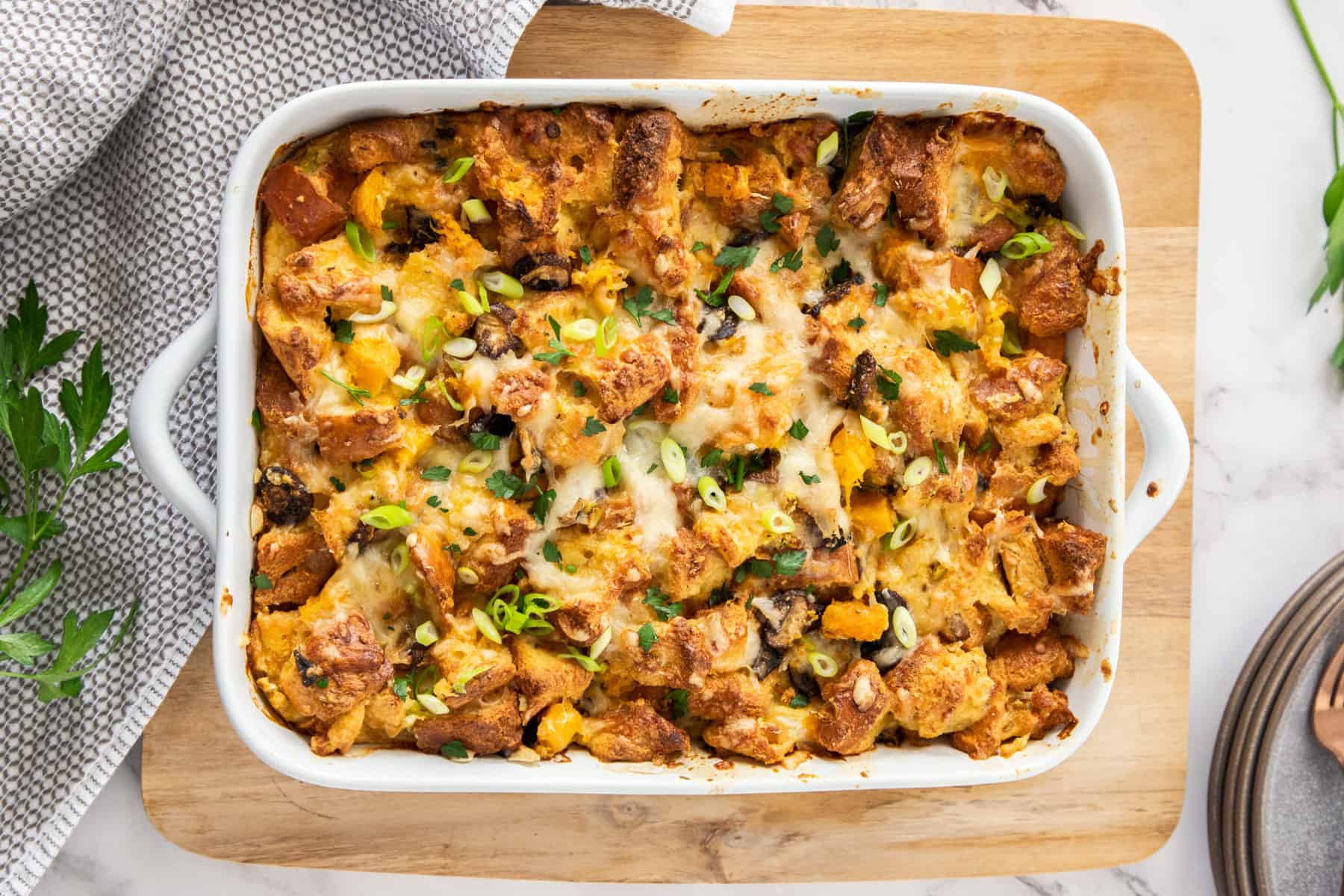 An overhead shot of a large dish of baked savory bread pudding