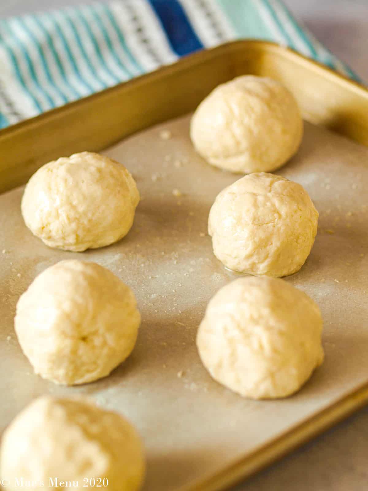 Balls of dinner rolls on a baking sheet ready to bake