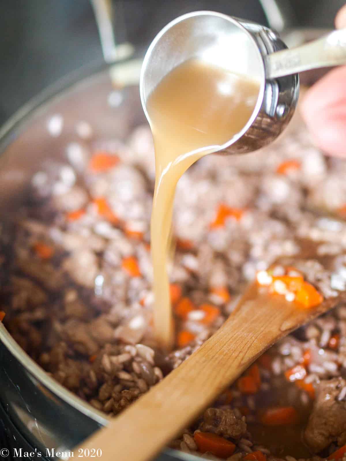 Pouring a ladle of broth into the rice