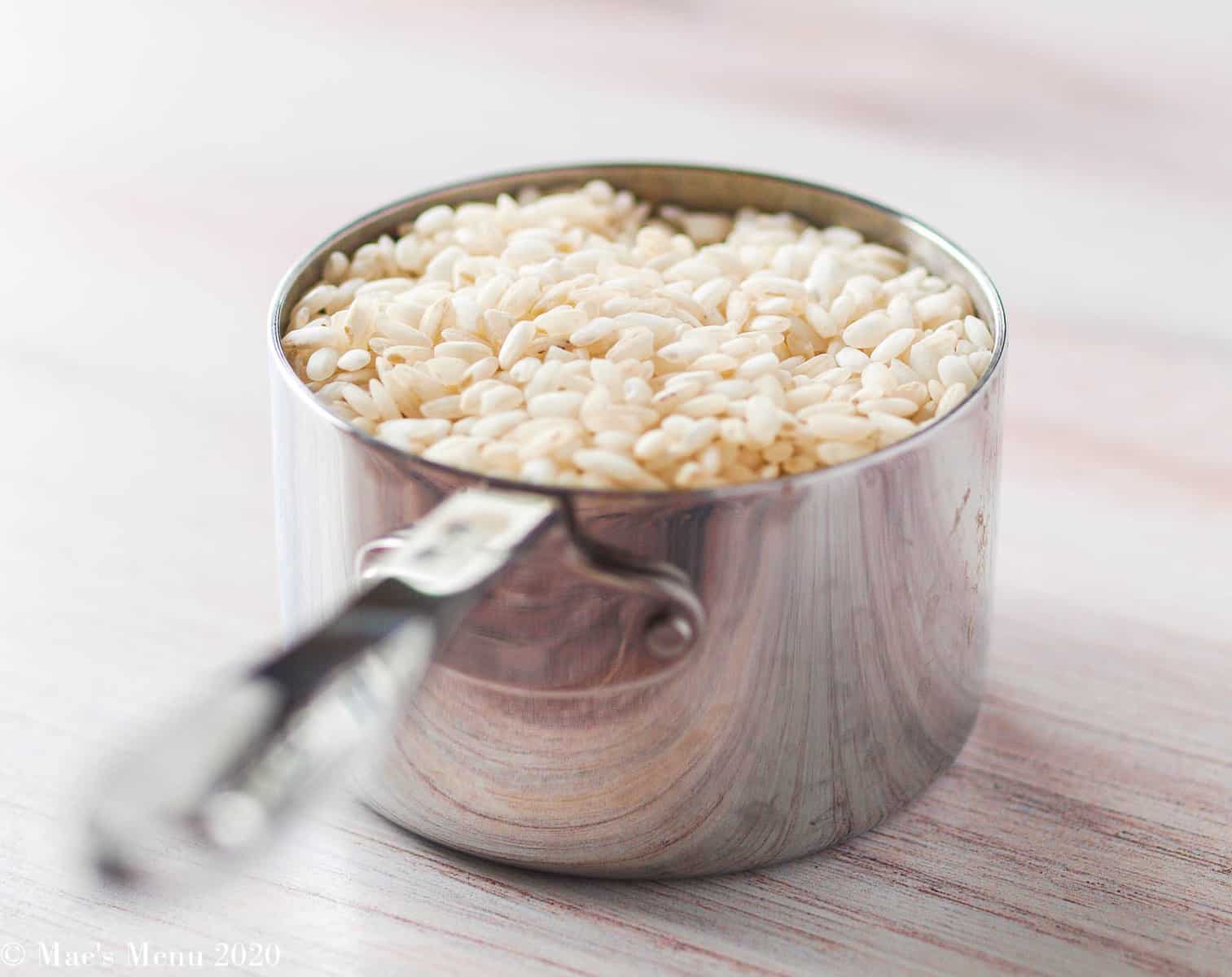 A measuring cup of risotto rice