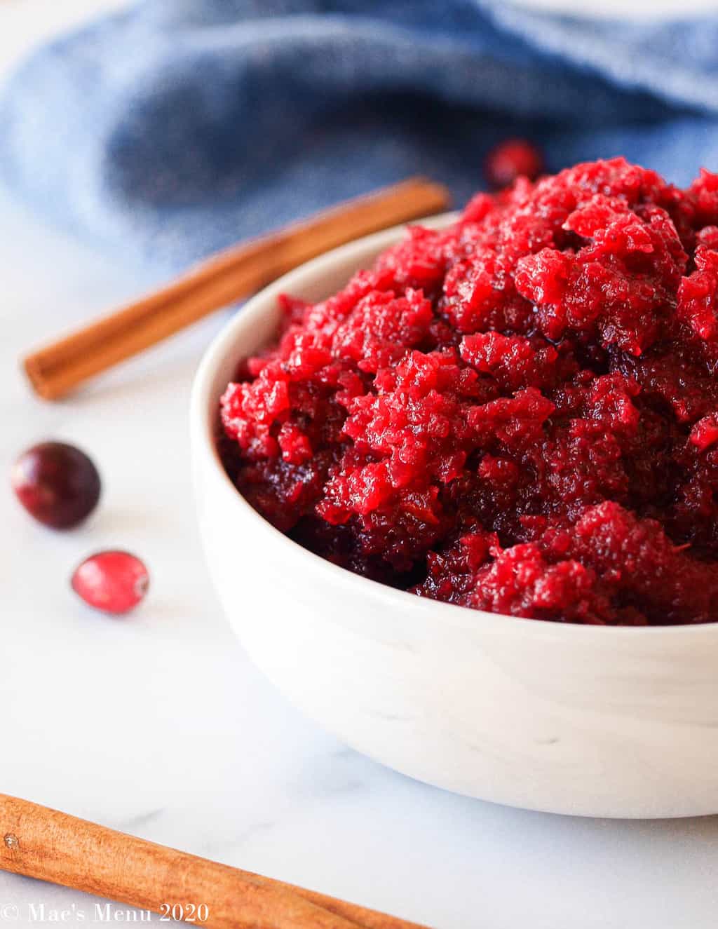 An up-close side shot of cranberry apple sauce on a marble counter