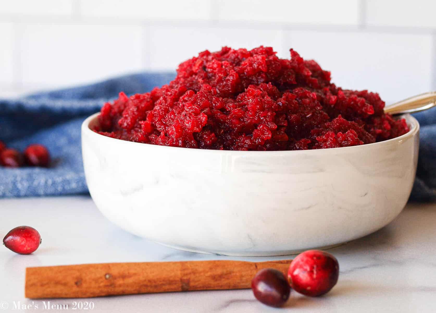 An up-close shot of a bowl of apple cranberry sauce in a white marble bowl
