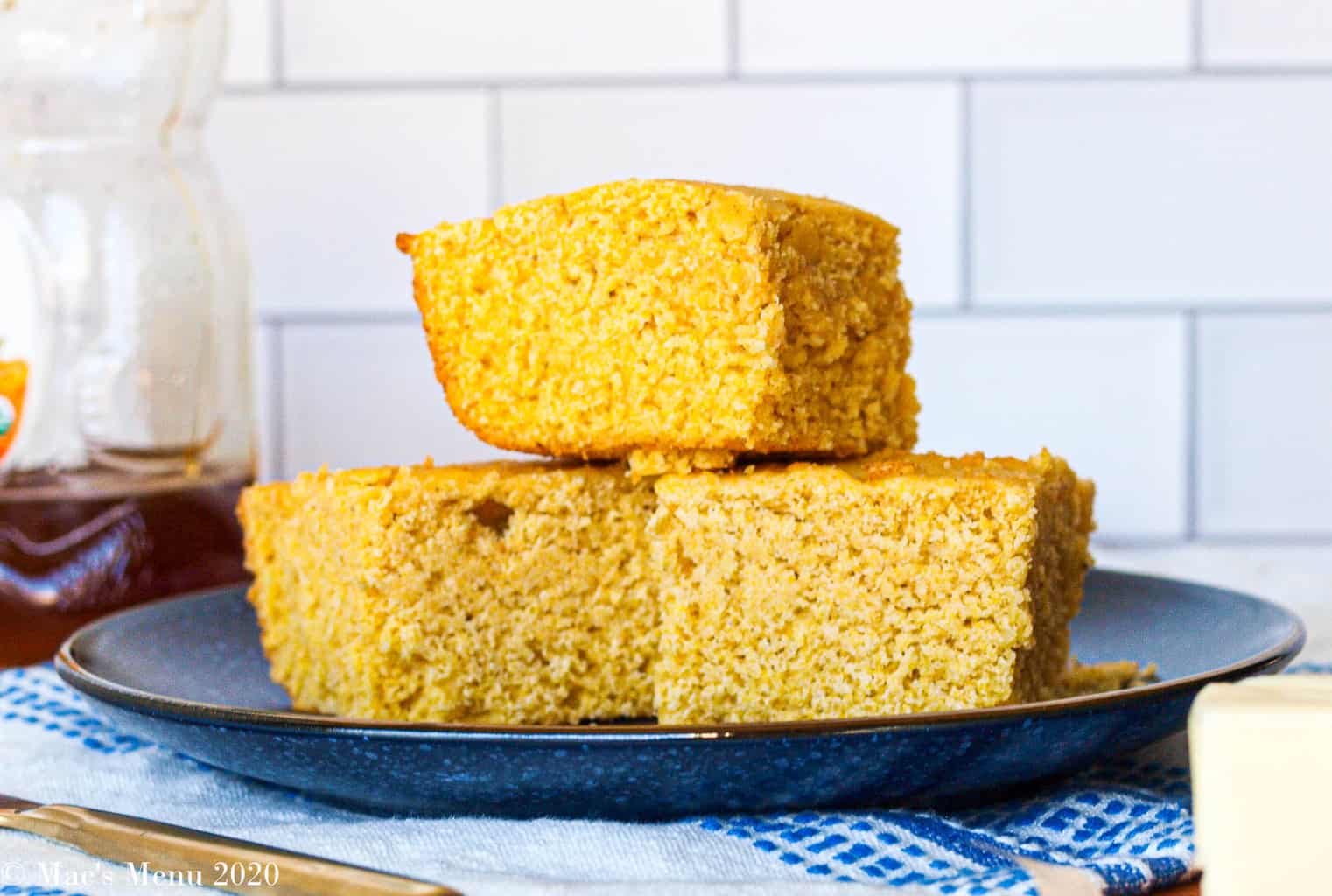 A Stack of gluten-free corn bread on a blue plate with white tile in the background