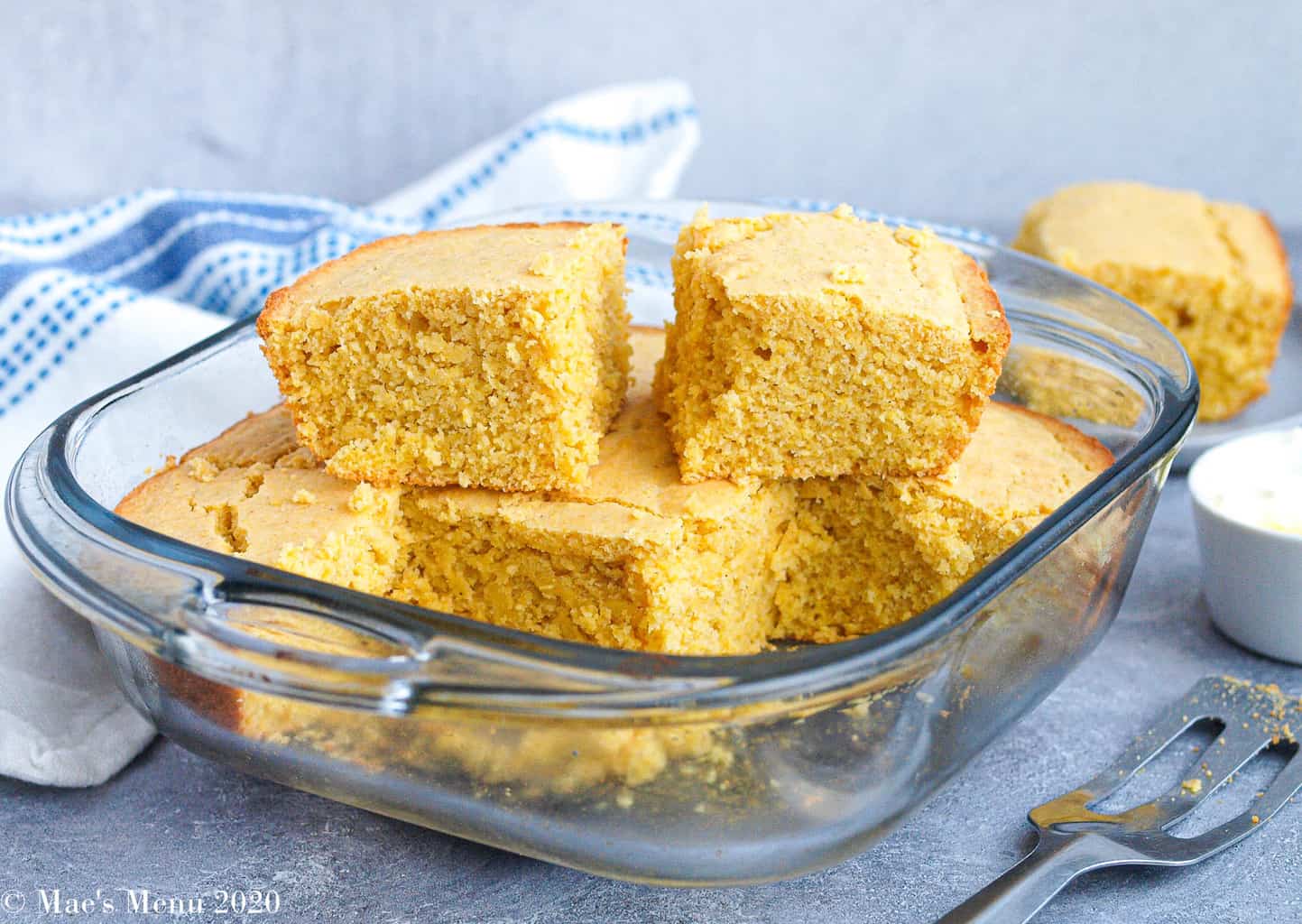 A clear glass pan with pieces of gluten-free cornbread stacked in it 