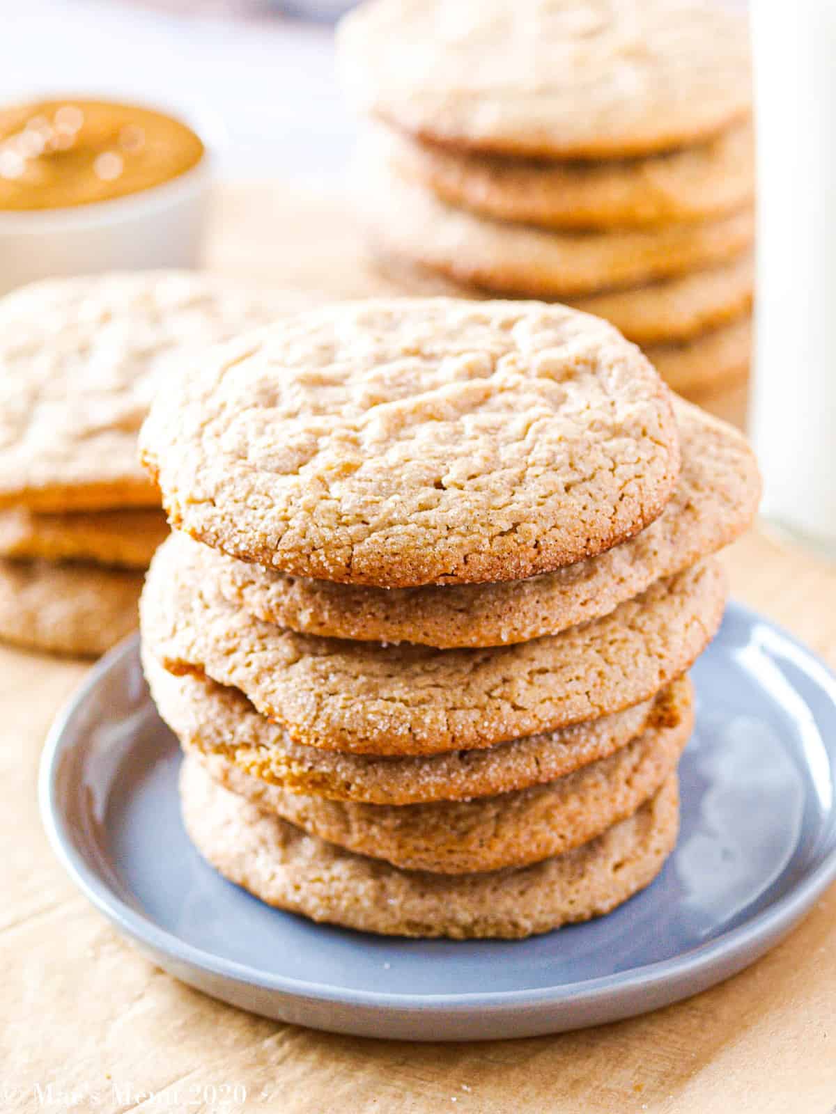 A large stack of whole wheat peanut butter cookies on a small smoky blue plate