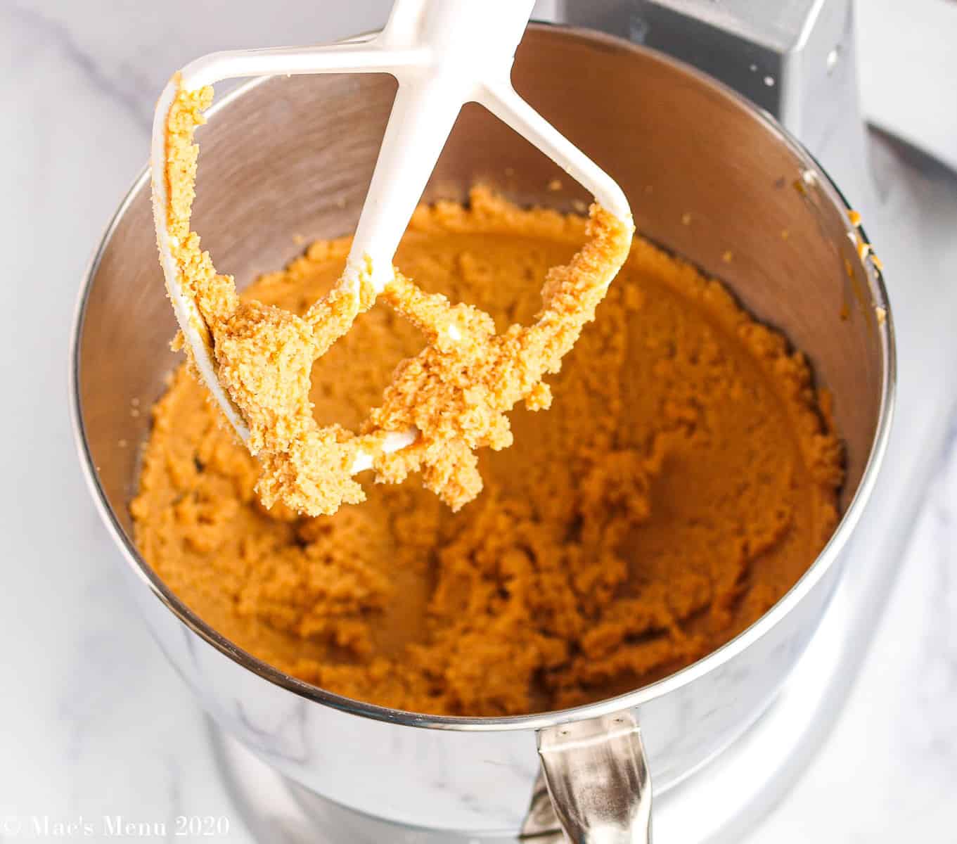 A stand mixer with a mixture of creamed butter, peanut butter, and sugar