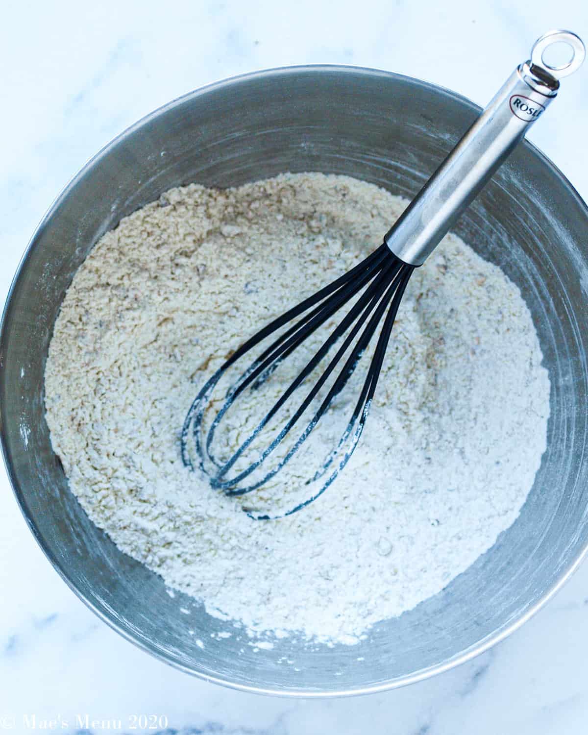 Whisking together all of the dry ingredients in a large metal mixing bowl