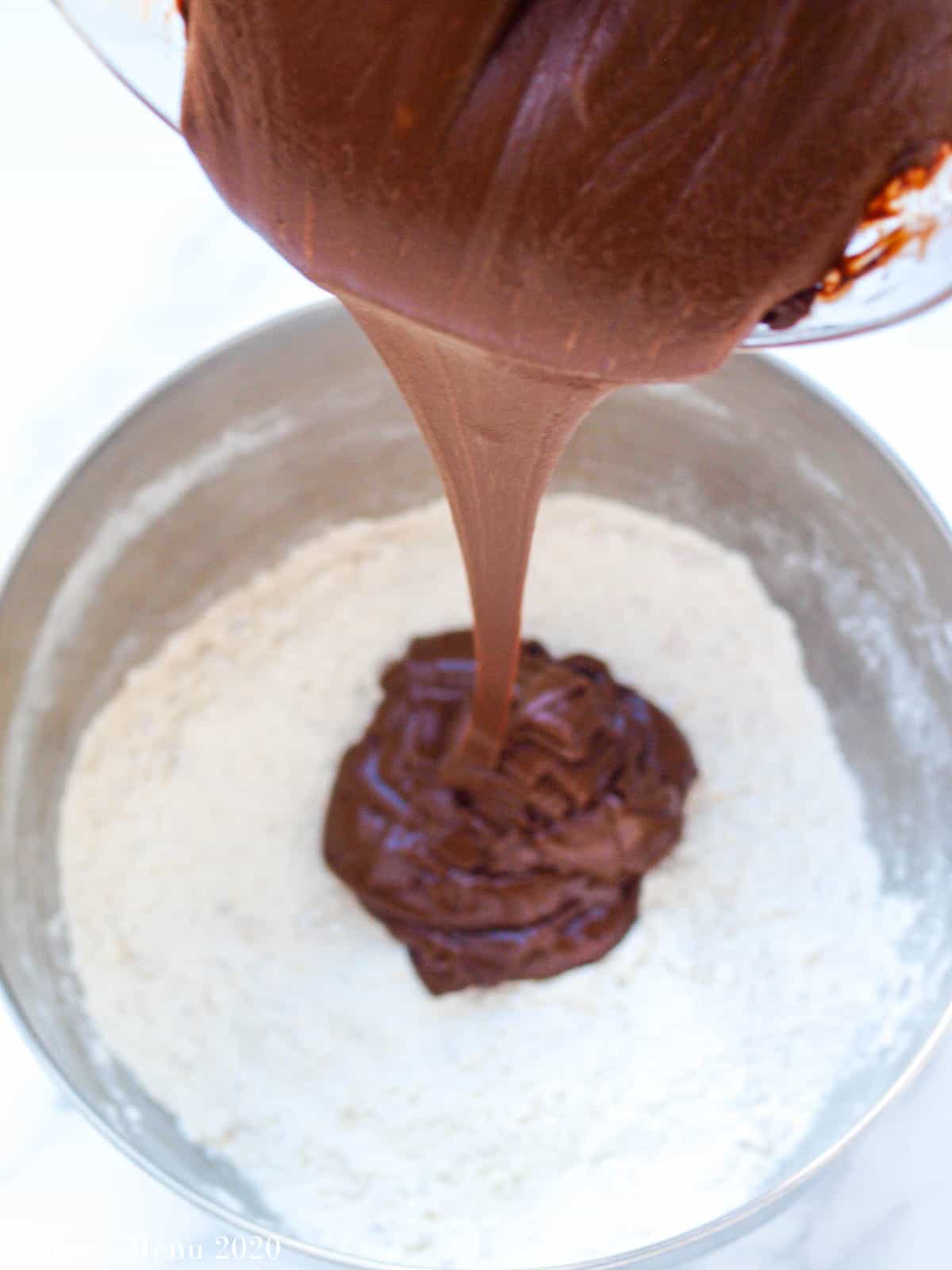 Pouring the melted chocolate mixture into the dry ingredients
