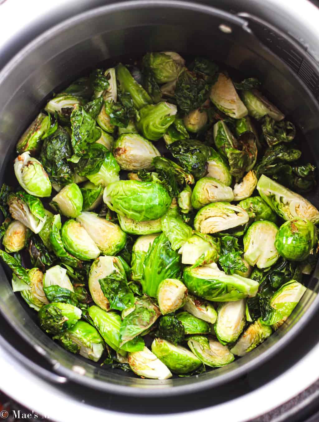 An air fryer of brussels sprouts as they fry