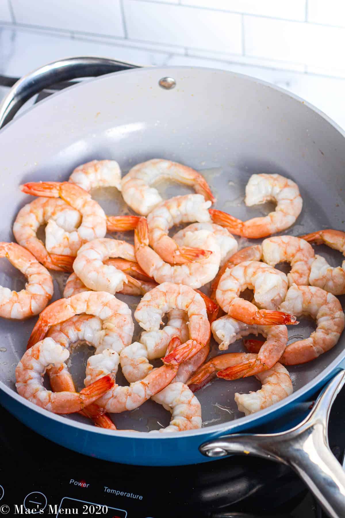 Cooking the shrimp until just pin in the blue pan 
