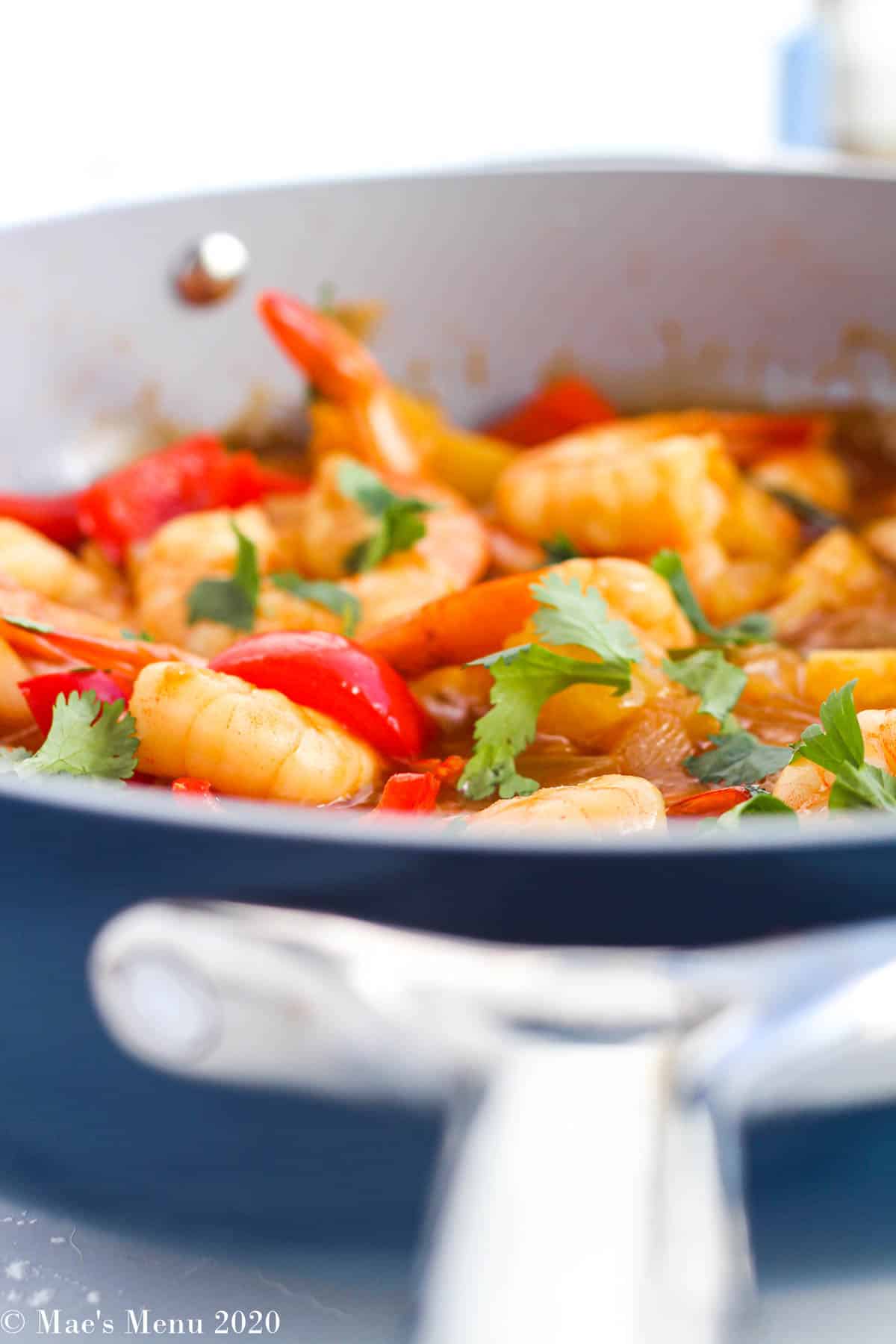 An upclose side angle shot of a pan  of sweet and sour shrimp
