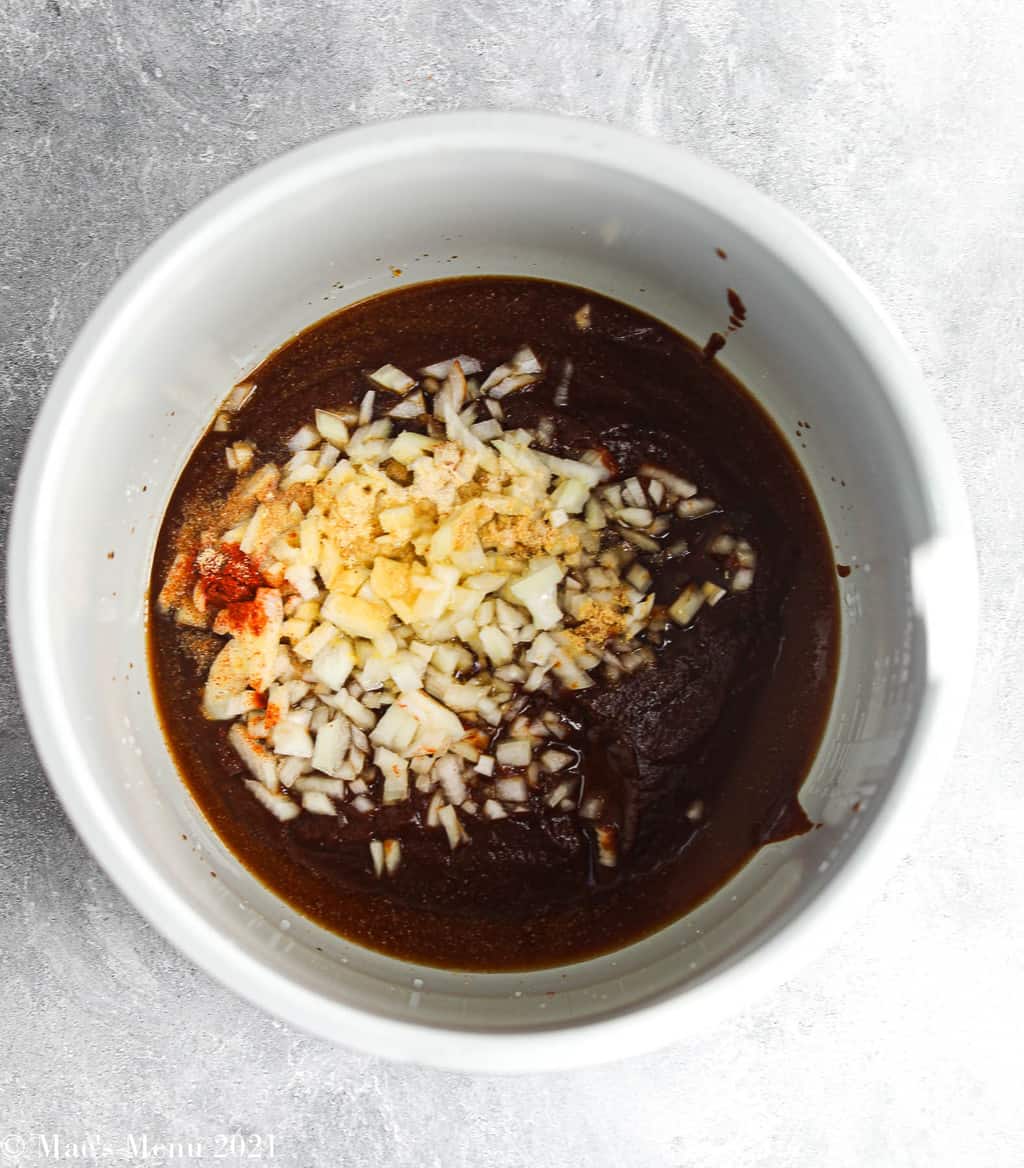 Barbecue sauce, onions, and seasonings in an instant pot bowl