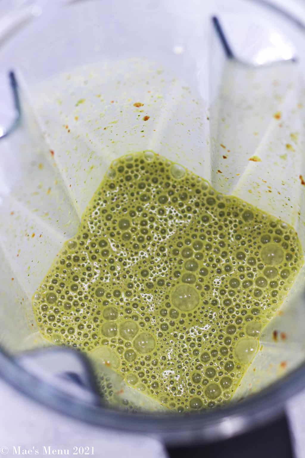 an overhead shot looking into the blender at the green date smoothie