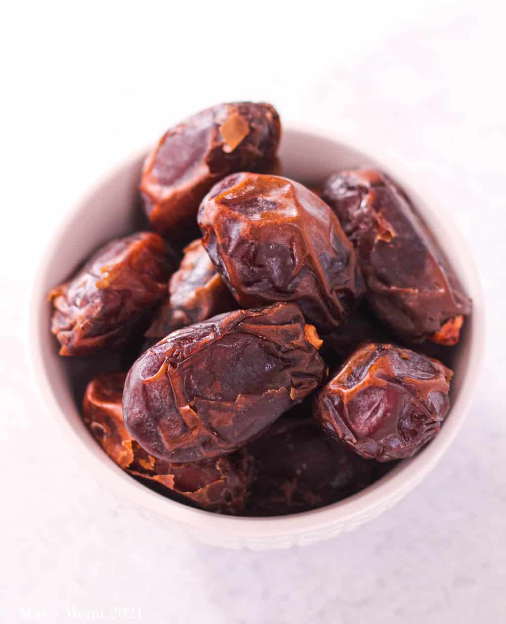 a small white cup of dates