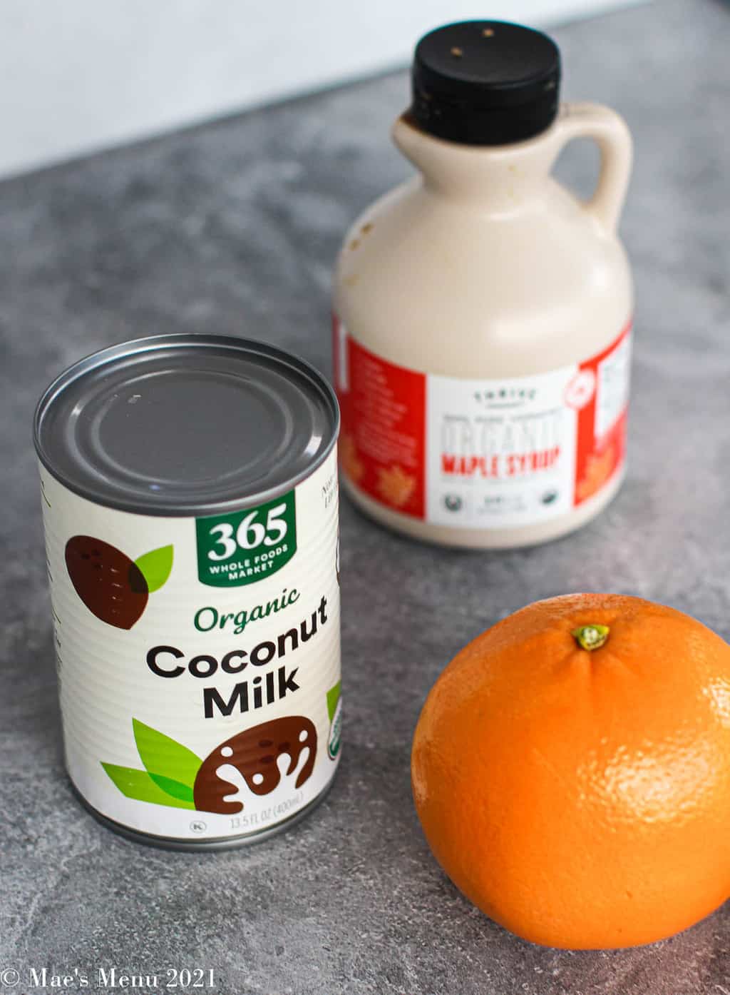 Ingredients for healthy sweet potato souffle: coconut mik, maple syrup, and an orange