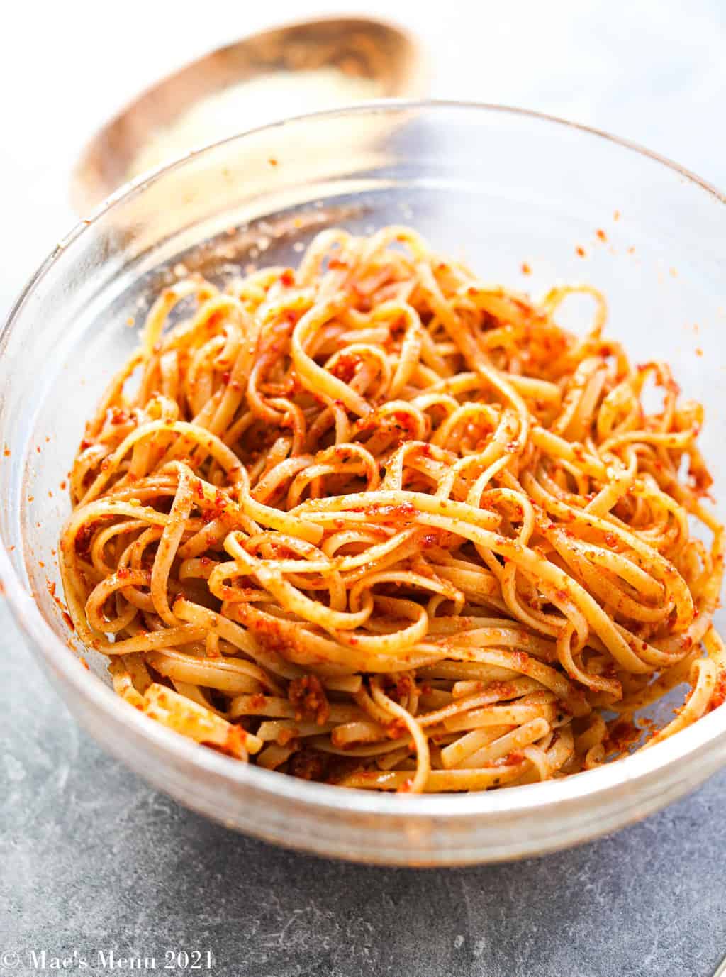 a glass bowl with linguine tossed with red pesto