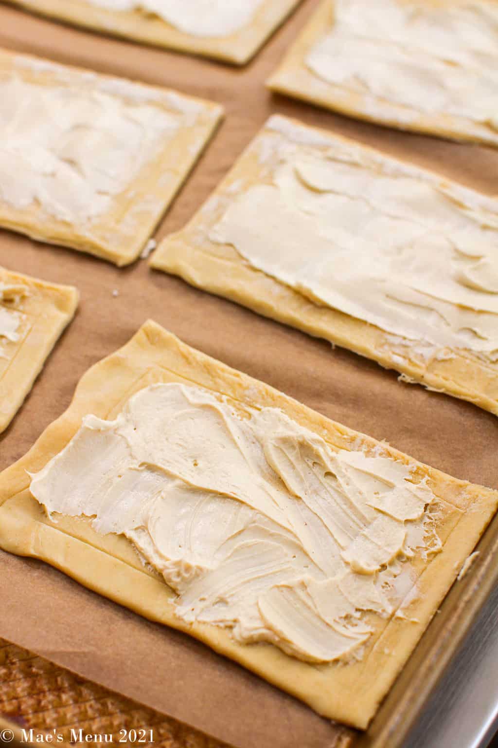 Up-close shot of puff pastry squares with dijon and cream cheese mix on top